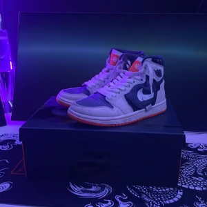 Nike Air Jordans i vit och blå - Snygga Nike Air Jordans i en cool kombination av vit och blå med orange detaljer. Kan sänka pris vid snabbt köp