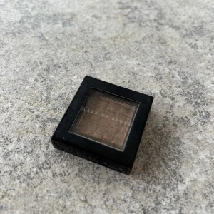 Ögonskugga från Make Up Store - Säljer en ögonskugga från Make Up Store i en elegant brun nyans. Den kommer i en fyrkantig svart förpackning med genomskinligt lock. Perfekt för att skapa en naturlig look eller för att bygga upp en mer dramatisk stil.