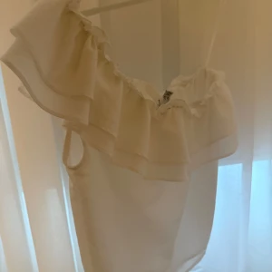 Vit oneshoulder topp med volang - vit oneshoulder topp med volangdetalj💕