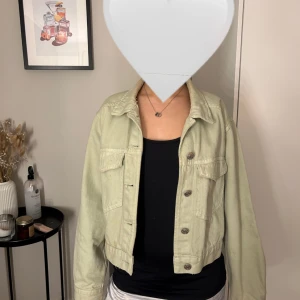 Ljusgrön jeansjacka - Snygg grön jeansjacka med knappar framtill och klassisk krage. Jackan har en croppad passform och långa ärmar, perfekt för vår och sommar. Passar xs 