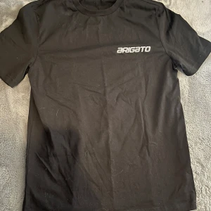Svart t-shirt från Axel Arigato - Snygg svart t-shirt från Axel Arigato med tryck av jordklotet och ett stort 'A' på baksidan. Framtill finns en liten logga. Perfekt för en stilren look.