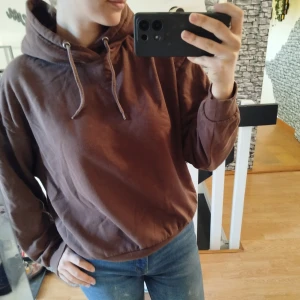 Brun hoodie - Säljer en brun hoodie med luva och dragsko. Perfekt för en avslappnad stil. Den har långa ärmar och en bekväm passform.