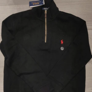 Svart Ralph Lauren tröja med dragkedja - Säljer en klassisk svart Ralph Lauren tröja med dragkedja. Tröjan är replika men ser exakt ut som är äkta. Tröjan är helt ny med tag. Storlek M men den är ganska liten i storlek. Det här är det lägsta priset jag kan erbjuda. Tröjan är oanvänd