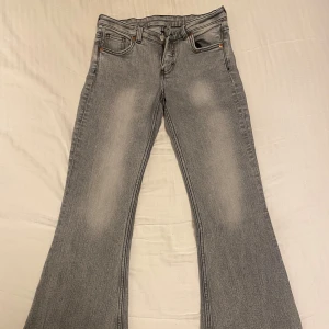 Grå bootcut jeans - Snygga grå bootcut jeans från monki i storlek 27/30. Sprättade längst ner.