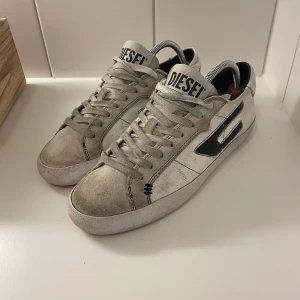  Diesel skor - Snygga vita sneakers från Diesel med svart detalj på sidan och snörning. Perfekta för våren/sommarn.
