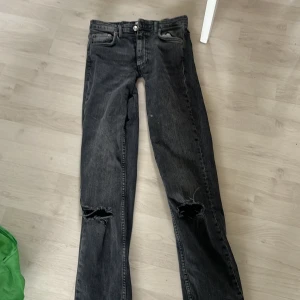 Lågmidjade bout cut - Snygga svarta jeans med slitningar på knäna väldigt lågmidhade och bootcut