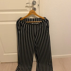 Svartvitrandiga byxor från Gina Tricot - Snygga svartvitrandiga byxor från Gina Tricot i storlek M. Byxorna har en rak passform och är perfekta för en stilren look. De är tillverkade i ett bekvämt material som passar både till vardags och mer uppklädda tillfällen.