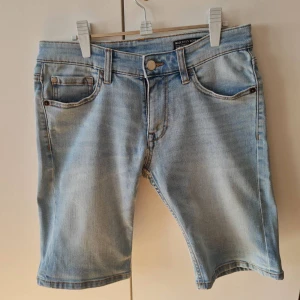Ljusblå jeansshorts från Cubus - Snygga ljusblå jeansshorts från Cubus. Klassisk design med knapp och dragkedja framtill. Perfekta för en avslappnad stil under sommardagar. Storlek W29. Kan hämtas i Vallentuna.
