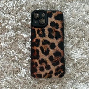 Leopardmönstrat mobilskal - Snyggt mobilskal med leopardmönster som ger din telefon en trendig look. Skalet har en svart kant och är designat för att skydda kameran. Perfekt för dig som vill ha en djärv stil.