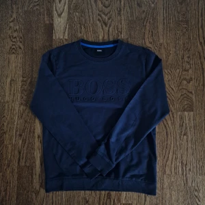 Mörkbkå Hugo Boss Tröja - Letar du efter en stilren och bekväm sweatshirt?  Säljer en Hugo Boss-kofta i nyskick för endast 499 kr!  ✔ Material: Lyxig & hållbar kvalitet. ✔ Storlek: S – smickrande passform. ✔ Stil: Klassisk & mångsidig design.  Perfekt för både vardag & fest!  📦 Snabb leverans – skickas samma dag! 📦  💬 Skicka meddelande vid intresse!  #hugoboss #herrmode #stilrent #hållbartmode #klassiskdesign  