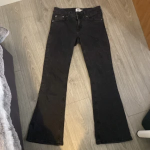 Svarta jeansbyxor - Snygga svarta jeansbyxor med bootcut-stil. Klassisk design med fem fickor och knappgylf. Perfekta för en stilren look.