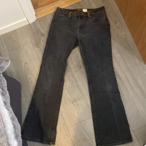 Svarta jeans från Street One - Snygga svarta jeans från Street One med bootcut-stil. De har dekorativa detaljer med pärlor på bakfickorna och en klassisk femficksdesign. Perfekta för en stilren look.