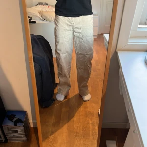 Beige byxor från Weekday - Snygga beige byxor från Weekday med en avslappnad passform. Byxorna har en rak stil och är tillverkade i ett bekvämt material. Perfekta för en stilren look. Passar dig som är runt 177-180