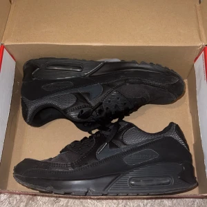 Svarta Nike Air Max sneakers - Säljer ett par svarta Nike Air Max sneakers. Skorna har en klassisk design med snörning och en bekväm sula. Perfekta för både vardag och träning.