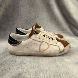 Phillipe model - Snygga sneakers från Philippe Model i vitt och brunt med svarta detaljer. Skorna har snörning och en stilren design med en kontrasterande brun tå och svart häl. Perfekta för en avslappnad stil. Hör av er av minsta funderingar MVH CH😄