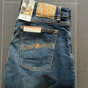 Nudie Jeans - Nudie Jeans av modellen Skinny Lin Storlek: 30/32 - Skicket på jeansen är ny med prislapp - 100/10 - mitt pris: 599- Nypris: 1599kr.   En stor fördel med Nudies jeans jämfört mot Levis, Tiger of Sweden, Replay, Lee, Acne, dondup osv. Ar att du kan lämna in dem gratis for reparation eller uppläggning i Stockholm, Göteborg eller Malmö. Pa sa vis förlängs livslängden rejalt.