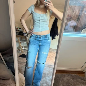 Grå topp - Jättefin T-shirt/topp med knappar. Den är ribbad och är lite croppad. 