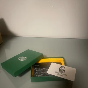 Svart plånbok från Goyar - Säljer en elegant svart plånbok från Goya med det ikoniska mönstret. Plånboken är kompakt och stilren, perfekt för att hålla dina kort och kontanter organiserade. Levereras i originalförpackning med en gul putsduk. Priset kan diskuteras. Frågor,skriv!