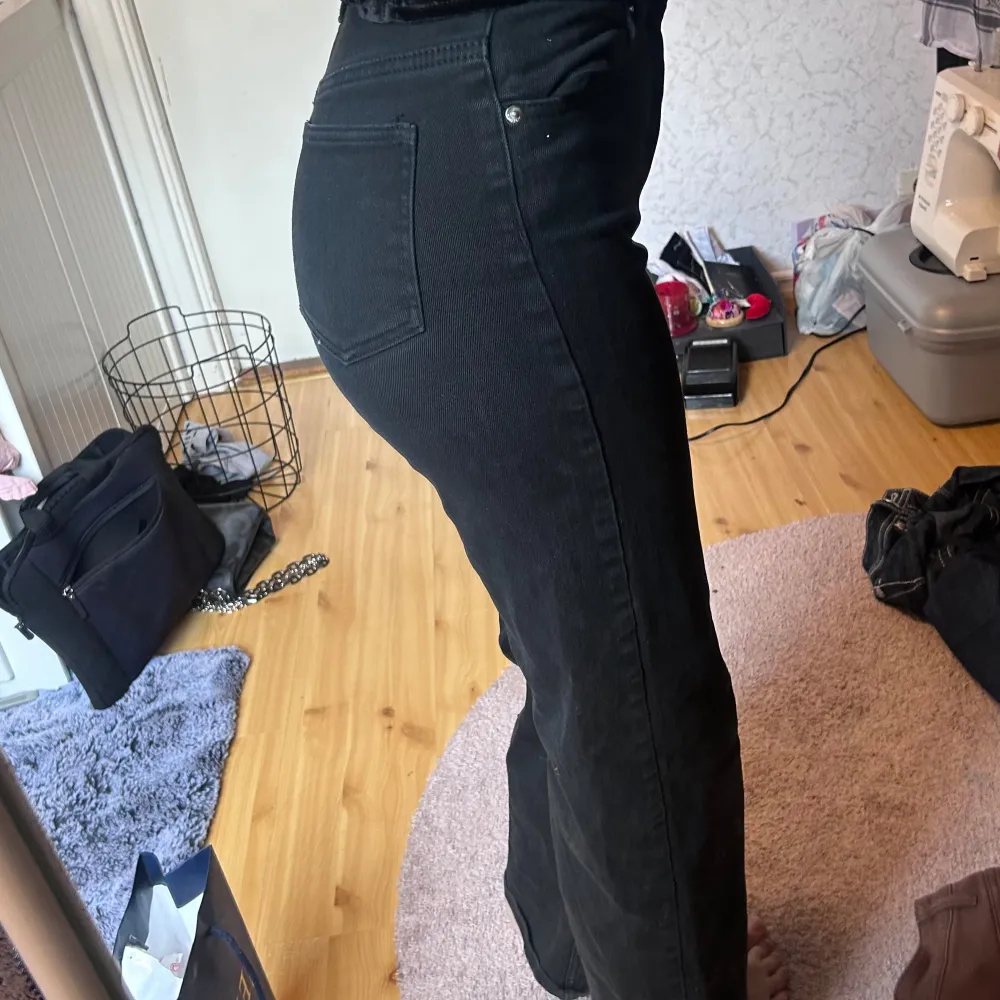 Snygga svarta jeansbyxor med hög midja och raka ben. De har en klassisk femficksdesign och stängs med dragkedja och knapp. Perfekta för en stilren look.. Farkut & Housut.