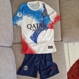 PSG Neymar Jr 10 fotbollströja Nike - Paris Saint-Germain matchkit med Neymar Jr och nummer 10 på ryggen. Snygg design i vitt med blå och röda detaljer, PSG-logga och Qatar Airways sponsortryck. Kortärmad, rund hals och tillverkad i Dri-FIT material som andas. Perfekt för dig som älskar fotboll och PSG.