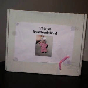 Virk-kit Rosettnyckelring - Vill du lära dig börja virka? Då kan du nu köpa ett virk-kit där du får med allt för att kunna göra en fluffig rosettnyckelring!