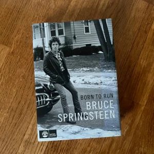 Born to Run - En snygg bok med svartvitt omslag där Bruce Springsteen står avslappnat vid en klassisk bil. Perfekt för dig som gillar musik, ikoniska artister och inspirerande berättelser. Passar dig som vill veta mer om rockens värld och dess legender.