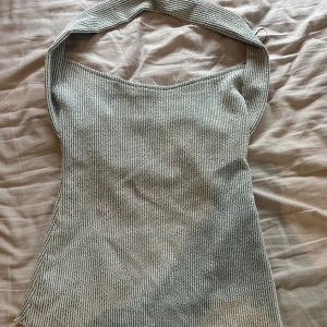 Glittrig silver bandeau tubtopp - Säljer en glittrig bandeau tubtopp i silver från Zara med ribbad struktur. Toppen är axelbandslös och har en snygg  passform som sitter tight mot kroppen. Perfekt för dig som vill sticka ut med lite extra shimmer. Materialet är mjukt och stretchigt syntet.