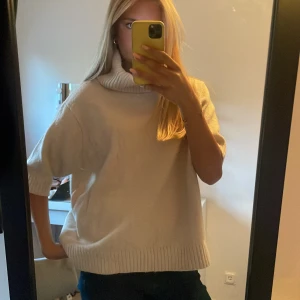 Beige stickad polotröja från Indiska - Mysig beige stickad polotröja från Indiska med korta ärmar och ribbade detaljer vid krage, ärmslut och nederkant. Den är i stl xl men sitter oversized på mig som bär s/xs! Perfekt för kyliga dagar och en stilren look. Använd 1 gång!!