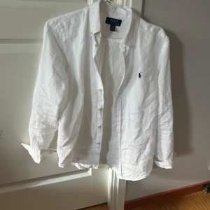 Vit linneskjorta från Polo Ralph Lauren -  Säljer en vit linne skjorta från Ralph Lauren Klassisk modell Som borde funka till vardag och fester. Den är lite för stor för mig och jag är 160 cm lång knappt aldrig använd som Mycket bra skick