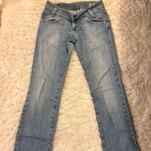 Ljusblå Lee jeans bootcut - Säljer ett par ljusblå jeans från Lee med klassisk bootcut-passform. Jeansen har fem fickor, snygga sömmar på bakfickorna och Lee-logga på linningen. Materialet är 98,5% bomull och 1,5% elastan för lite stretch. Dragkedja och knapp framtill. Pris går absolut att diskutera!