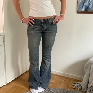 bootcut jeans blå - Säljer ett par jeans i blå tvätt med bootcut passform. De har låg midja, snygga slitningar och är vintage hm. De är bra skick och har knappt tecken på användning. 