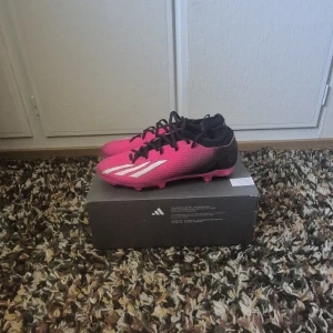 Adidas X Speedportal.3 FG fotbollsskor - Säljer ett par Adidas X Speedportal.3 FG fotbollsskor i en riktigt snygg rosa och svart färg med vita detaljer. Skorna har snörning och platt sula med dobbar för gräsplan. Knappt använd, slutade med fotbollen och hann inte använda dem så mycket. Är annars som nya. Har kvar kvitto och lådan.