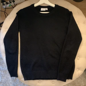 Svart stickad tröja från VILA - En svart stickad tröja från VILA i storlek XS. Tröjan har rund hals, ribbade muddar vid ärmslut och nederkant samt långärmad passform. Jätte skön och varm, stolek S passar ocskå💗säljer även exakt en sån här i vit också💗inga fläckar eller hål, lite nopprig men inget man tänker på💗