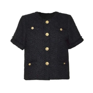 Svart blus med guldknappar - Snygg svart blus med korta ärmar och exklusiva guldknappar framtill. Blusen har en grovstickad struktur och rund halsringning, samt fickor med dekorativa knappar. Perfekt för dig som gillar en chic och trendig look. Endast testad men har tyvärr klippt bort prislappen.