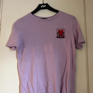 T-shirt från Zara x Keith Haring - Snygg lila t-shirt från Zara i samarbete med Keith Haring som inte kommer till användning längre. 
