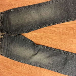 Levi's 511 blå jeans - Snygga blå Levi's 511 jeans med klassisk femficksdesign och smal passform. Jeansen har en mörk tvätt med lätt slitning och tydliga kontrastsömmar. Tillverkade i slitstarkt denim med dragkedja och knappstängning. Perfekta för dig som gillar en modern och stilren look.