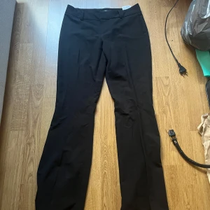 Svarta kostymbyxor från Vero Moda - Snygga svarta kostymbyxor från Vero Moda i strl 32/s. De är lite utsvängda och har inga fickor. 