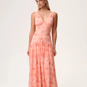 Peachfärgad långklänning från Adoore - Klänning från Adoore i modellen Toulouse. Den är helt oanvänd med båda etiketterna kvar på. Den är i storlek 38 men passar en 36 pga den snävare passformen. Pris kan eventuellt diskuteras. 