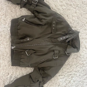 Olivgrön bomberjacka från Zara - Säljer en olivgrön bomberjacka från Zara med  spännen och detaljer på ärmarna. Den är i storlek S. Har aldrig använt den.