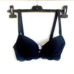 Helt NY! Svart Cubus Bh-strl D70- modell U Bella Padded Bra - Säljer den här helt nyköpta bh-n från Cubus då den blev köpt i fel storlek. Tyvärr hann dottern rycka bort lapparna men det syns att den är helt ny och aldrig använd;) Den är svart, vadderad med spets, se foton. Strl D70 och själva modellen heter U Bella Padded Bra.