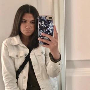 Vit jeansjacka med knappar - Snygg vit jeansjacka med klassisk krage och silverfärgade knappar framtill. Jackan har två bröstfickor med lock och långa ärmar. Jackan är varsamt använd och är i storlek s