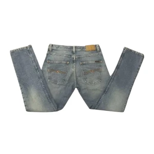 NUDIE GRIM TIM - Säljer dessa fina Nudie jeans i den populära modellen Grim Tim! Byxorna är i toppskick men har en YTTERS liten prick vid knät. Helt osynlig när man har på sig dem (se sista bilden). Dessa är även i en sample färg som heter "summer storms" och vad jag vet går inte att få tag på längre. Jeansen är lite mera ljusblå i verkligheten än på bilderna och mått finns ifall man vill ha. Tveka inte att höra av dig vid frågor!