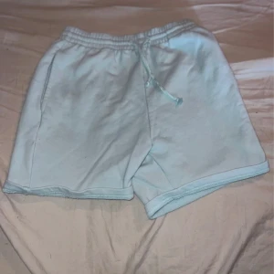 Ljusblå mjukisshorts från Pull&Bear - Ljusblå mjukisshorts från Pull&Bear med elastisk midja och snörning. Shortsen har en relaxed fit och är tillverkade i mjuk bomull, perfekta för chill dagar. Fickor på sidorna och enkel design som passar till allt.