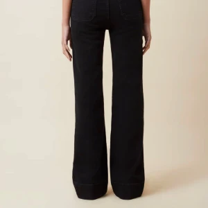 Jeanerica Svarta bootcut jeans - St Monica - Snygga svarta jeans från Jeanerica med hög midja och bootcut-ben. Jeansen har två stora fickor framtill och är tillverkade i ett klassiskt denimtyg. Använda en gång. Stl. W26/L32