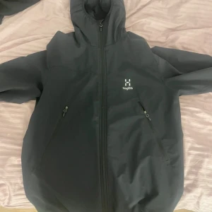 Svart vindjacka från Haglöfs med huva - Svart vindjacka från Haglöfs med hel dragkedja och justerbar huva, inget resårband i midjan. Nästan helt ny utan defekter. Kom privat för fler frågor.
