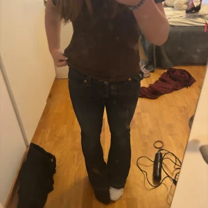 True Religion bootcut jeans mörkblå - Säljer ett par mörkblå bootcut jeans från True Religion med snygga kontrastsömmar och ikonisk fickdetalj bak. Jeansen är i mid Rise och har längden 90 cm.  Klassisk femficksmodell i jeansmaterial.