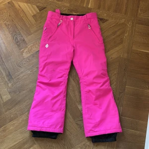 Skidbyxor vinterbyxor - Supersnygga rosa skidbyxor med justerbar midja och snölås. Fickor fram med dragkedja, strlk 150