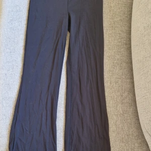 Svarta bootcut byxor Gina Tricot - Svarta bootcut byxor från Gina Tricot med en fin detalj i midjan. Har andvänts några gånger men är i bra skick. Säljer pga att dom har blivit för små.
