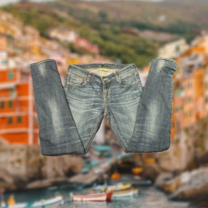 Jacob Cohën Jeans - Snygga blå jeans från Jacob Cohën med klassisk femficksdesign och guldfärgade sömmar. Jeansen har en rak passform och är tillverkade i bomull med en lätt tvättad look. Broderad logga på myntfickan och tydlig branding på insidan av linningen.