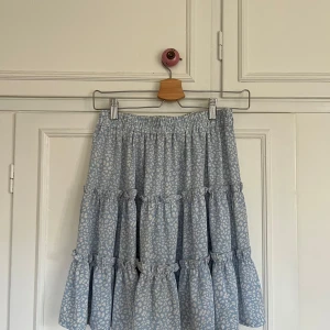 Blå volangkjol med leopardmönster - Supersöt blå kjol med volanger och vitt leopardmönster. Resår i midjan och luftig med flera lager som ger volym. Aldrig använd🤍